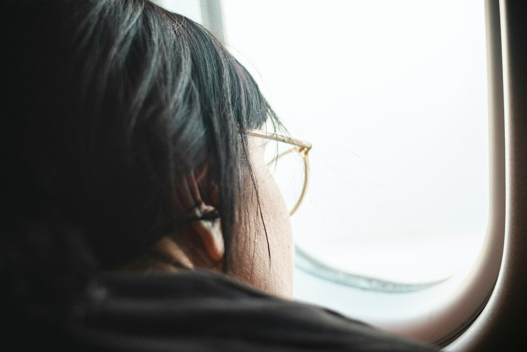 Person reflecting quietly while looking out a window