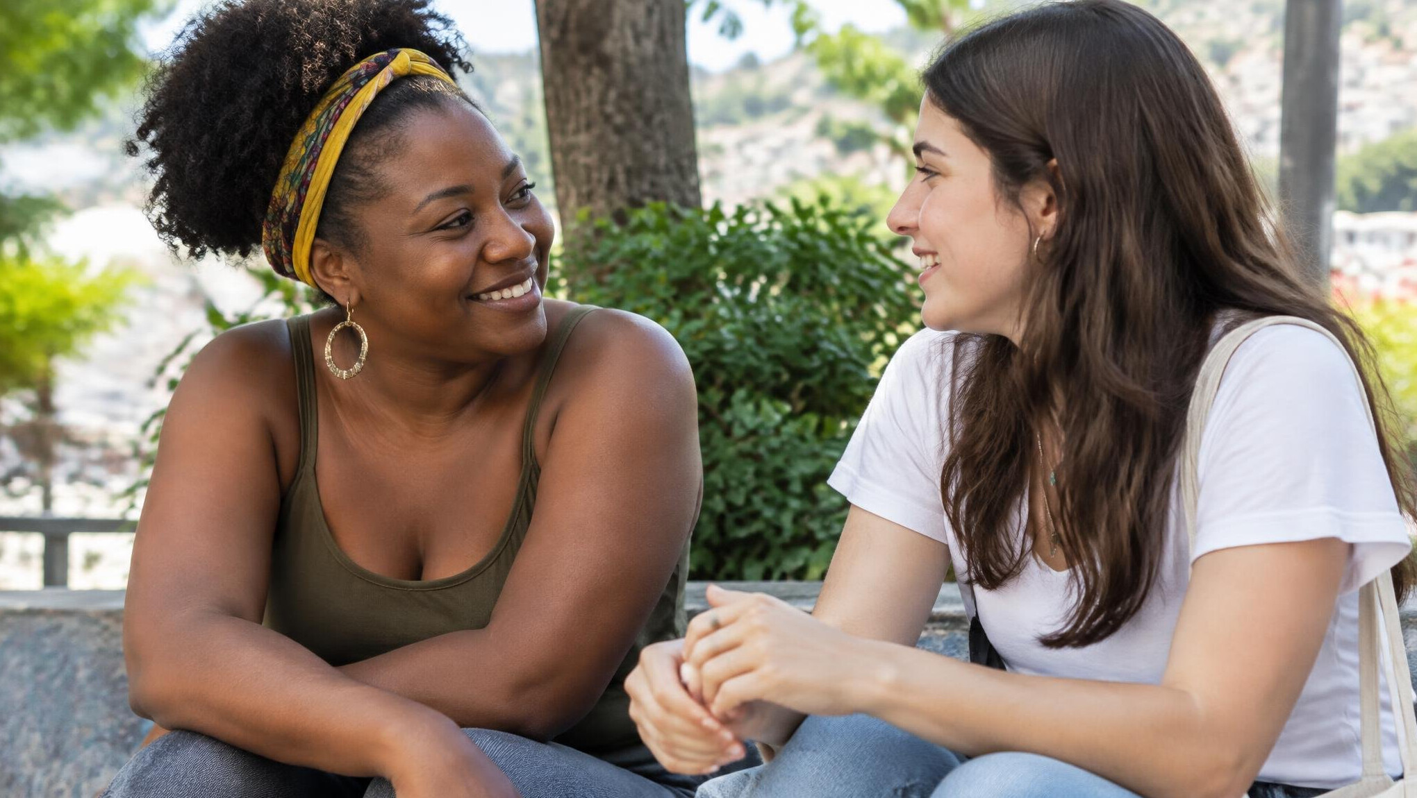 Two Brazilian women having a warm, attentive conversation outdoors