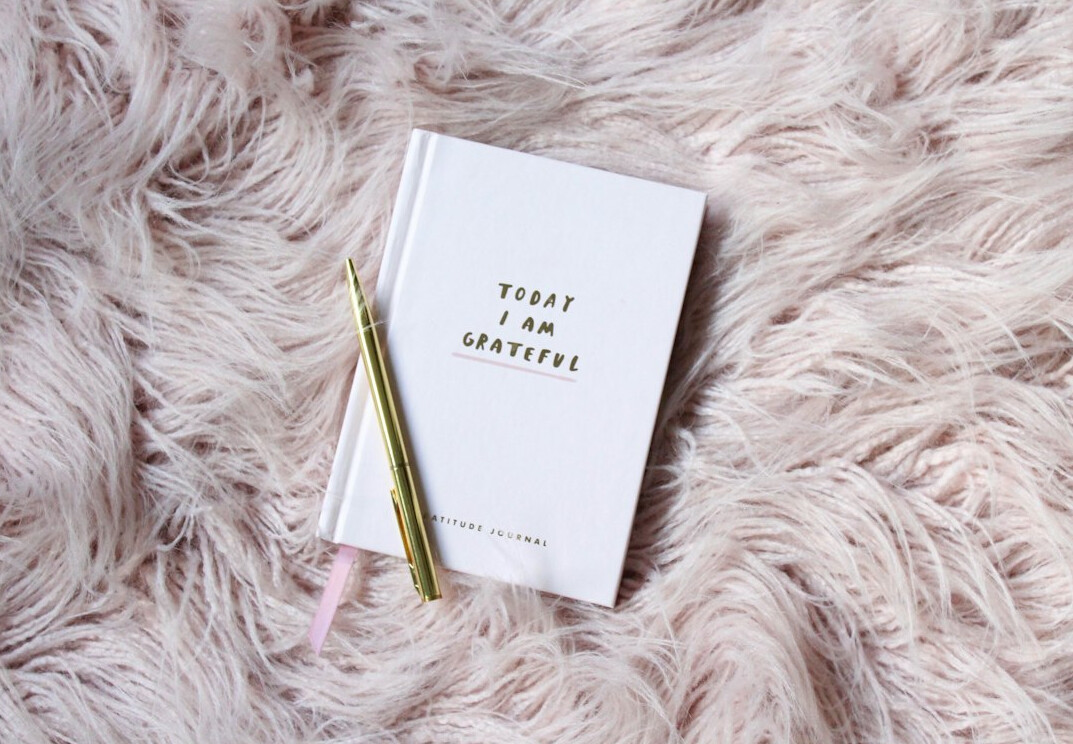 Open journal with a pen on a desk near a window